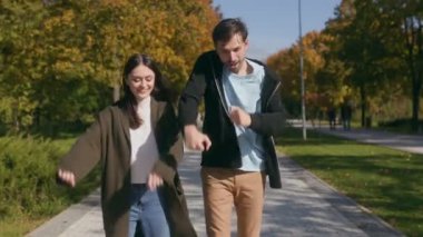 Gelişigüzel giyinen genç bir çift, manzaralı bir sonbahar parkında dans ediyor, anın keyfini kucaklıyor. Kaygısız enerjileri ve aşkları iç açıcı bir sahne yaratıyor..