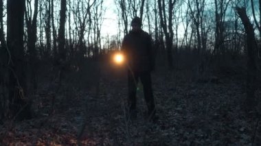 Karanlık ormanı kesen bir fener huzmesi bir adam gecenin derinliklerine doğru ilerlerken önemli bir aramayı işaret ediyor..