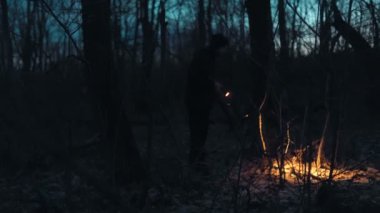 Sessiz bir gece, bir ormanda el feneriyle bir adamı sarar. Bilinmeyeni aramak için gölgelerde gezinirken, bakışları odaklanmış ve kararlıdır..