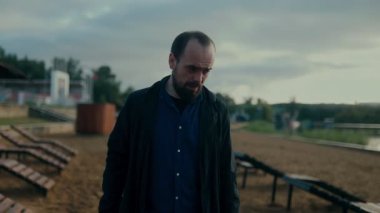 Yumruklarını sıkarak ve acı çeken bir yüzle bir adam sanki öfkesini salıyormuş gibi dramatik bir jest yapar. Sahildeki bu duygusal patlama saf zihinsel acıyı gösteriyor..