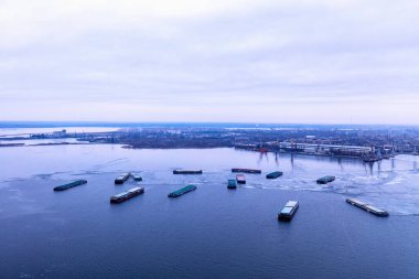 Donmuş bir nehirde duran bir kargo gemisi. Nakliye konsepti, ithalat ihracat ve iş lojistiği, kışın hava manzarası. Nikolaev, Ukrayna