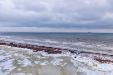 Deniz ve nehir arasında tükür. Açık deniz fırtınasının arka planına karşı gri kış günü