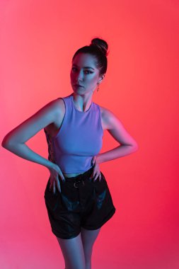 Modaya uygun, neon ışığı olan güzel bir kadın. Kulüp titreşimleri. Biçimli seksi kız..