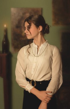 Sanat stüdyosunda duran genç bir kız resimlere bakıyor ve hayal kuruyor..