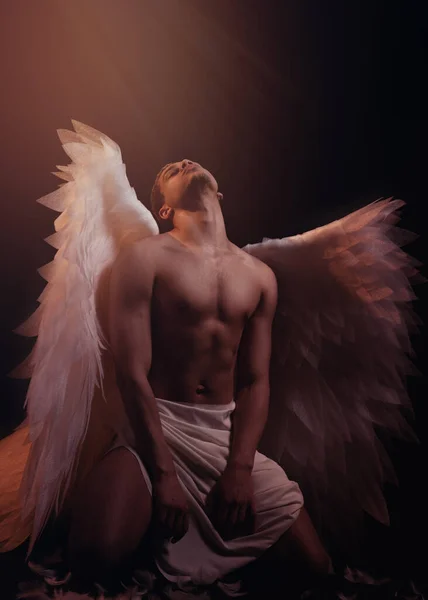 年轻强壮的天使 有着来自天堂的白色翅膀 天使与肌肉的身体 性感男人 免版税图库图片