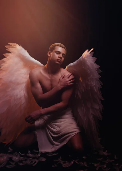 年轻强壮的天使 有着来自天堂的白色翅膀 天使与肌肉的身体 性感男人 免版税图库照片