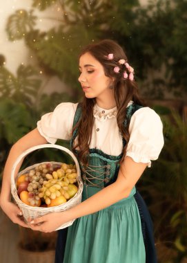 Bahçede elinde meyve sepeti olan genç bir kız. 19. yüzyıl bavyera elbisesi giymiş..