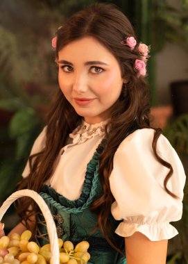 Bahçede elinde meyve sepeti olan genç bir kız. 19. yüzyıl bavyera elbisesi giymiş..