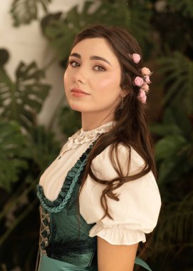 Bahçede dikilen genç bir köylü kadın. 19. yüzyıl Bavyera elbisesi giymiş..