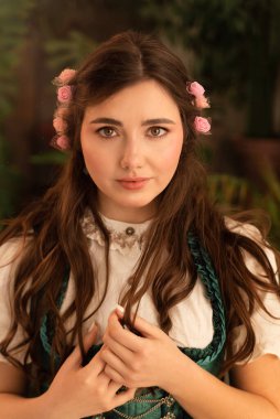 Bahçede dikilen genç bir köylü kadın. 19. yüzyıl Bavyera elbisesi giymiş..