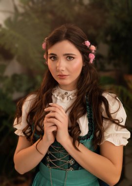 Bahçede dikilen genç bir köylü kadın. 19. yüzyıl Bavyera elbisesi giymiş..