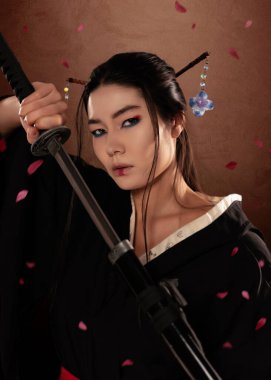 Japon kadın samuraylar kimono giyiyorlar ve kahverengi arka planda katana tutuyorlar ve çiçek yaprakları. Japon kültürü
