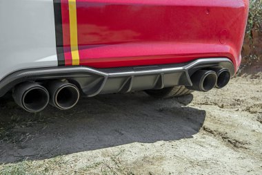 Beyaz spor arabalı kırmızı egzoz sistemi. Performans araba egzoz sistemi. Modern araçta yarış tipi susturucular