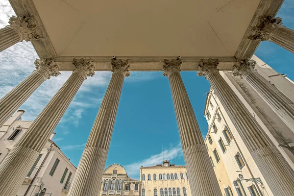 Abstract low wide angle perspective view of the Chiesa di San Nicola da Tolentino columns on Campo dei Tolentini in Venice, Italy. Beautiful contrast scene with blue sky and marble buildings