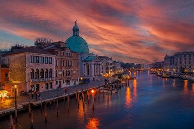İtalya 'nın Venedik kentindeki Ponte degli Scalzi (çıplak ayaklı rahiplerin köprüsü) Grand Canal' dan güzel bir günbatımı manzarası. Solda Santa Croce, suda yansıma