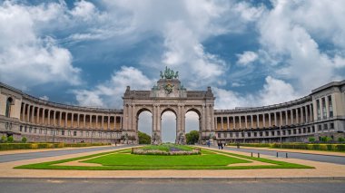 Brüksel 'deki Cinquantenaire Parkı' nın panoramik manzarası ve Belçika 'nın 1880 yılındaki bağımsızlığının kutlamaları için inşa edilen kemer bulutlu mavi gökyüzü altında. Belçika 'nın ünlü bir simgesi.