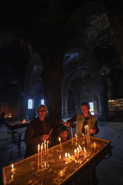 Saghmosavan, Ermenistan - 03 Mayıs 2025: Ermeni dini ailesi, Ermenistan 'ın Aragatsotn Eyaleti Saghmosavank (13. yüzyıl) köyündeki bir manastırda mum yaktı.