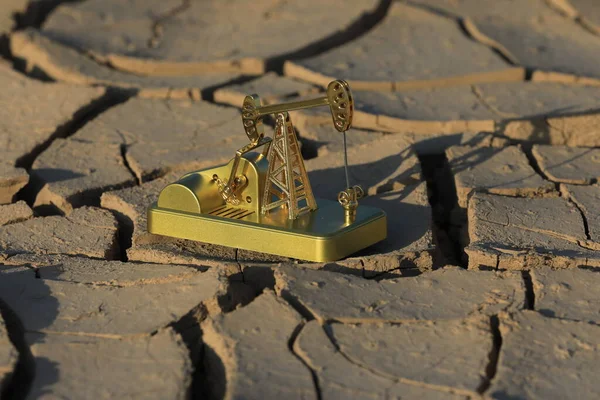 Golden model of an oil pump on dry land in Kazakhstan.