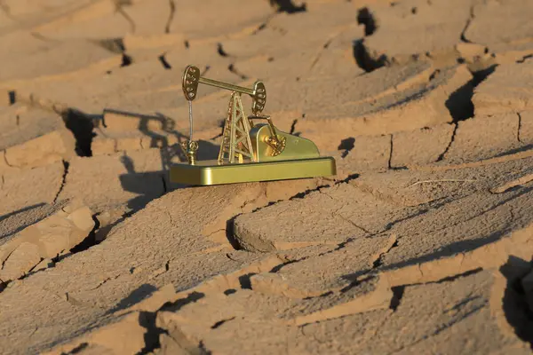 Golden model of an oil pump on dry land in Kazakhstan.