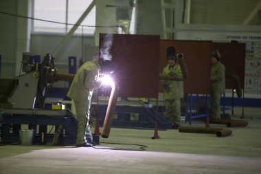 İşçiler Almaty 'deki yalıtılmış bir boru fabrikasına kaynak yapıyorlar. 11.23.2011