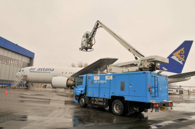 Özel bir makine Kazakistan 'daki Almaty Uluslararası Havalimanı' nda bir uçak kanadına krema önleyici sıvı veriyor. 11.10.2007