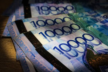 10,000 tenge 'lik parçalar masanın üzerinde duruyor.