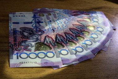 10,000 tenge 'lik parçalar masanın üzerinde duruyor.