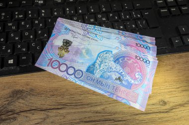 Yeni 10.000 tenge klavyenin yanındaki masada yatıyor..