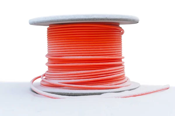 雪中有橙色电缆的木制电缆鼓 与白色隔离 免版税图库图片