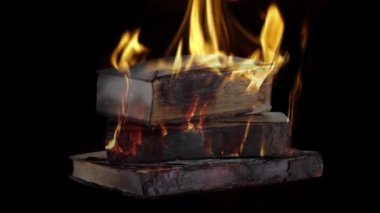 Siyah arkaplanda yanan kitap yığını