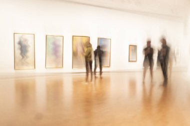 Art exhibition or museum with people in blurred motion studing the paintings clipart