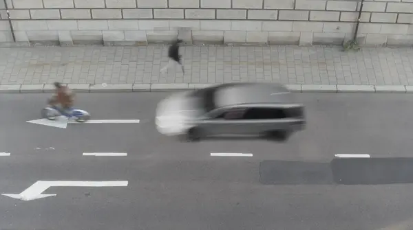 アスファルト サイクリスト 歩行者 ぼやけた動きの車の矢印付きのストリートの高角度ビュー ストック画像
