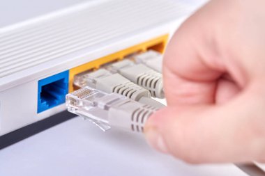El, internet kablosunu yönlendiriciye yerleştirir, yakın plan..