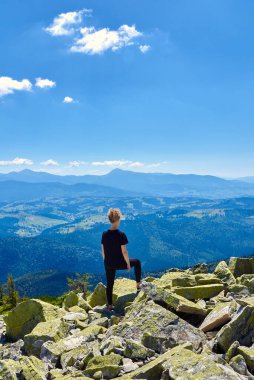 Kayalık bir dağın tepesinde bir kadın, boşluğu kopyala.