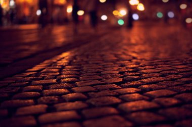 Gece şehrinin arka planında kaldırım taşı var. Yakın plan..