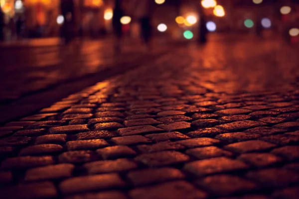 Gece şehrinin arka planında kaldırım taşı var. Yakın plan..