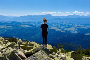 Kayalık bir dağın tepesinde bir kadın, boşluğu kopyala.