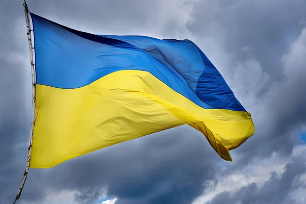 Die Ukrainische Flagge Weht Gegen Den Bewölkten Himmel lizenzfreie Stockfotos