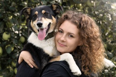 Sonbaharda bir kadın büyük bir köpeğe sarılır..