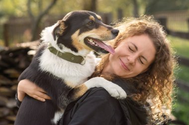 Büyük bir köpek dışarıda bir kadının yüzünü yalıyor..