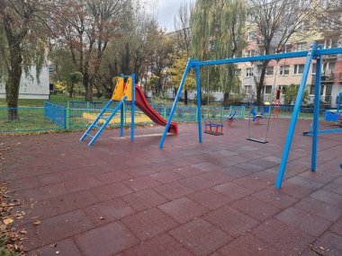 Yağmurlu bir sonbahar sabahı renkli salıncaklı çocuk parkı