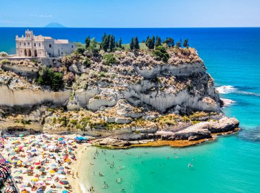 Yaz boyunca Calabria 'daki Tropea Panoraması' nda ziyaretçiler plajda tembellik ederken görülüyor.