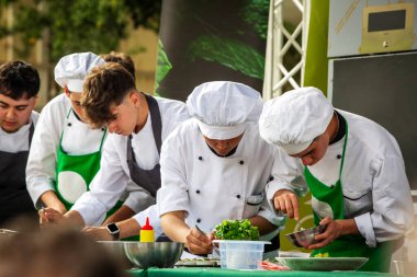 Imperia, İtalya 05-05-2024 - Liguria 'da bir aşçılık etkinliğinde aşçılar, meşgul seyirciler önünde yeteneklerini sergiliyorlar, yerel gastronomi ve geleneği tanıtıyorlar...