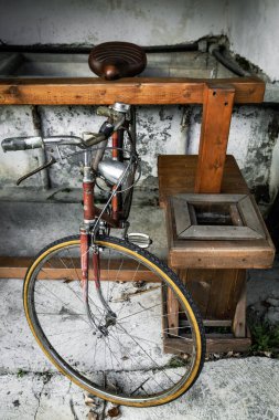 1970 'lerin antika bir bisikletin kırsal bir depodaki ön görüntüsü, nostaljik ruh hali ve otantik ayrıntılar..