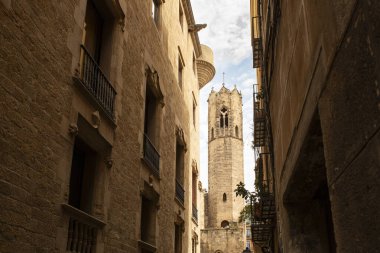 Barcelona 'daki Katedral Kulesi' nin ayrıntıları sıcak bir yaz gününde Gotik Mahallesi 'ndeki binalar arasında çerçevelenmiştir..