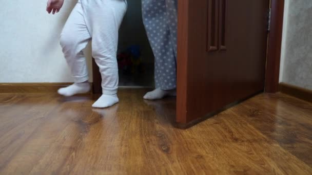 穿着轻便裤子和袜子的母亲和孩子的腿走进了房间的门 后续行动 — 图库视频影像
