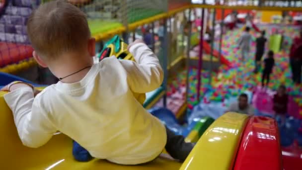 Mały Chłopiec Przychodzi Żółtym Dużym Ślizgaczem Pokoju Zabaw Zbliżenie Filmik — Wideo stockowe
