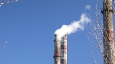  Mavi gökyüzüne karşı fabrika bacasından çıkan beyaz buhar ve duman. Hava kirliliği, emisyon, istasyon, iklim değişikliği, küresel ısınma, fabrika, endüstri kavramı. Yandan ateş ediyorlar.