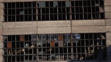 Savaştan sonra cam kırıkları olan eski bir sanayi fabrikasının dış cephesi. Ürkütücü endüstriyel bileşim. Hareket halinde, sağa doğru dönüyor.