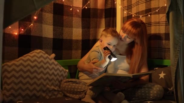 Молодая Беременная Мать Маленький Сын Пижаме Ночлежке Читают Книгу Светят — стоковое видео